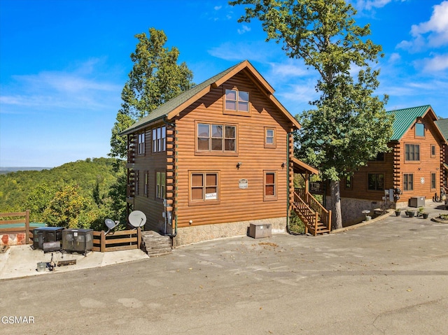 back of property with log siding and central air condition unit