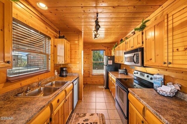 kitchen with wooden walls, rail lighting, appliances with stainless steel finishes, wooden ceiling, and a sink