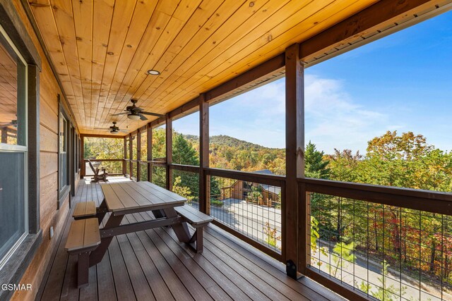 sunroom featuring ceiling fan and wood ceiling