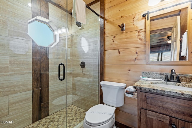 bathroom with vanity, toilet, an enclosed shower, and wooden walls