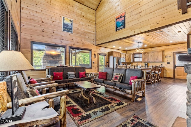 living room with wood walls, dark hardwood / wood-style flooring, wooden ceiling, and high vaulted ceiling