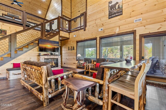 dining space with high vaulted ceiling, a wealth of natural light, and wood walls