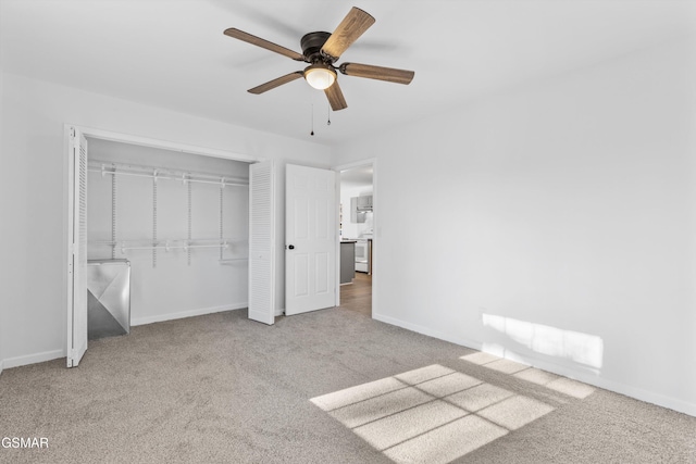 unfurnished bedroom with carpet floors, a closet, baseboards, and a ceiling fan