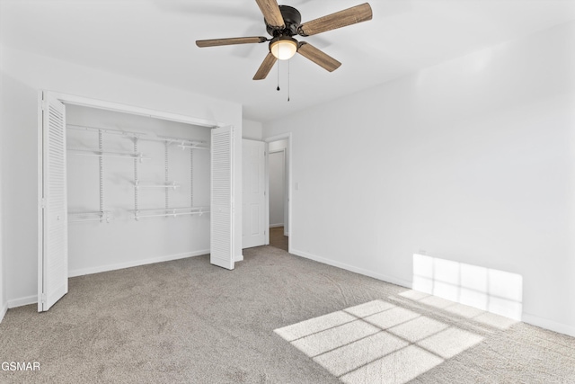 unfurnished bedroom with ceiling fan, a closet, baseboards, and carpet flooring