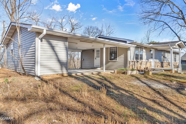 ranch-style home featuring a carport, driveway, and a porch