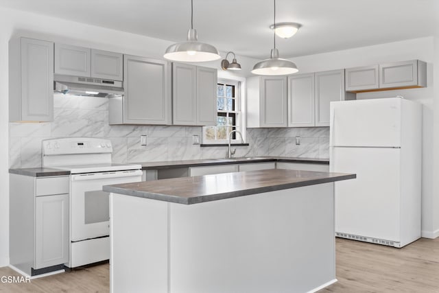 kitchen featuring gray cabinetry, white appliances, a sink, and under cabinet range hood