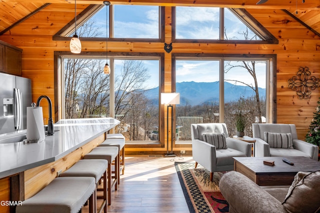 sunroom / solarium with a mountain view, wood ceiling, and vaulted ceiling