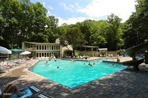 view of swimming pool featuring a patio area and a water slide