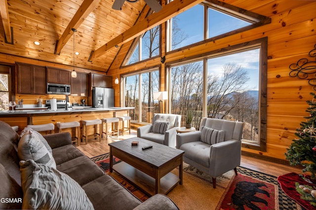 living room featuring light hardwood / wood-style flooring, high vaulted ceiling, wooden ceiling, beamed ceiling, and plenty of natural light