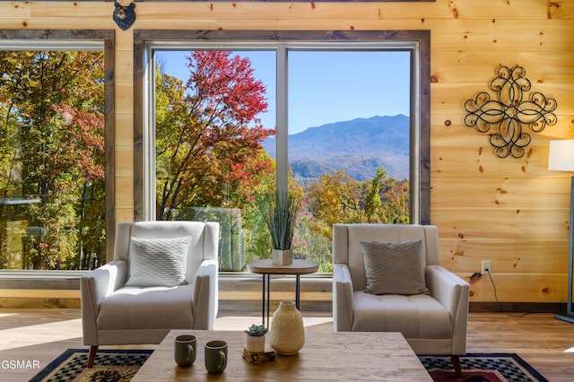 sitting room featuring a mountain view, hardwood / wood-style flooring, and wood walls