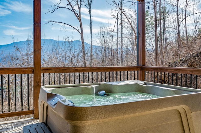 deck with a mountain view and a hot tub