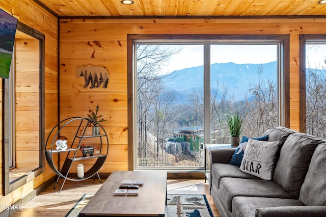 living room with a mountain view, wood walls, and wood ceiling