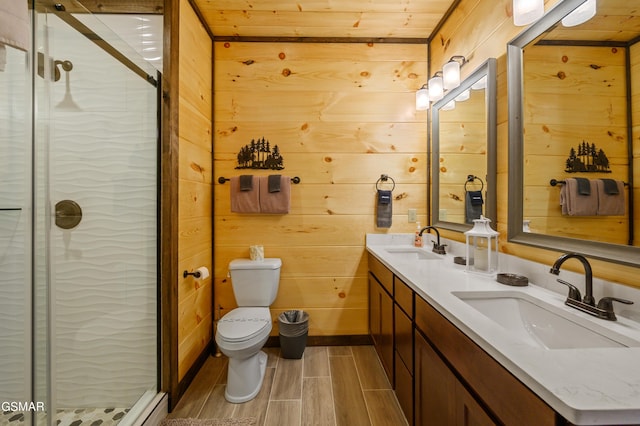 bathroom featuring wooden walls, a shower with door, vanity, and toilet