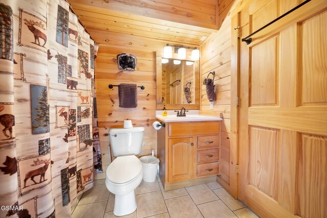 bathroom featuring tile patterned floors, toilet, vanity, and wood walls