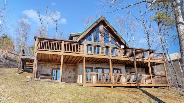 back of house featuring a wooden deck and a lawn