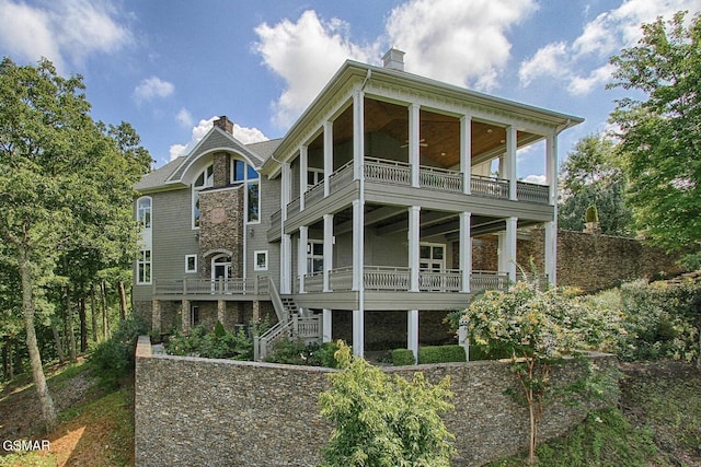 rear view of property featuring stairway and a chimney