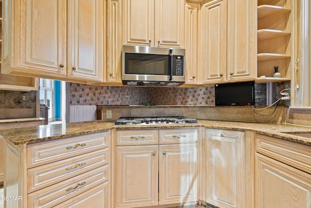 kitchen featuring stainless steel appliances, backsplash, open shelves, and light stone countertops