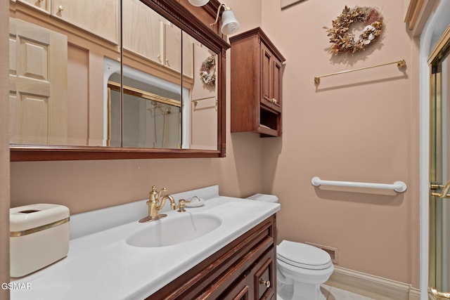 full bathroom with toilet, a shower with door, baseboards, and vanity