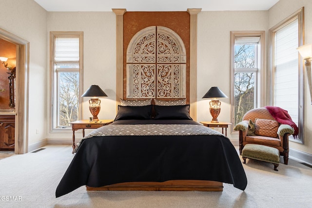 bedroom with multiple windows, carpet flooring, visible vents, and baseboards