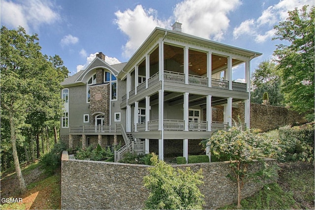 rear view of house featuring stairway and a chimney