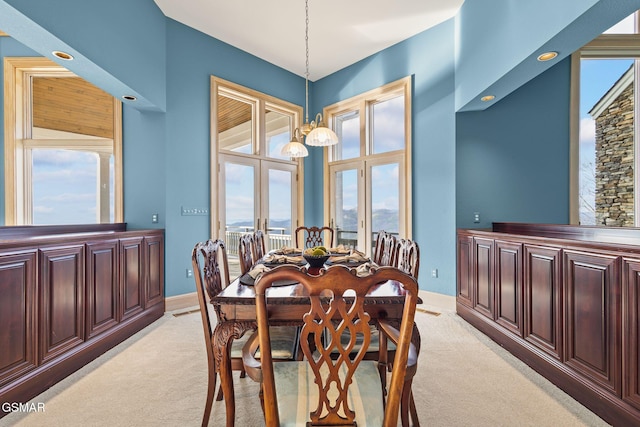 dining room with french doors, a wealth of natural light, and light colored carpet