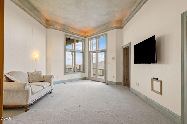 living area featuring carpet, baseboards, and ornamental molding