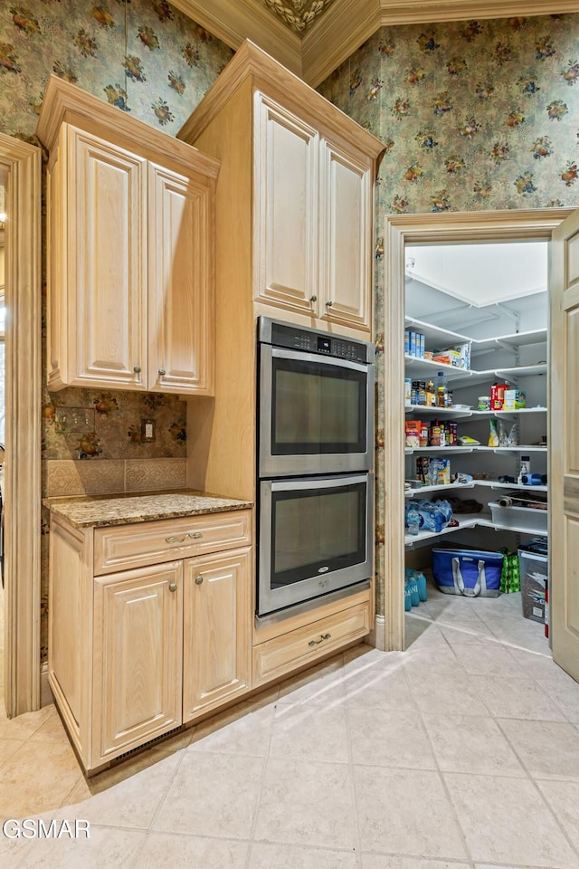 kitchen with stainless steel double oven, light tile patterned flooring, and wallpapered walls