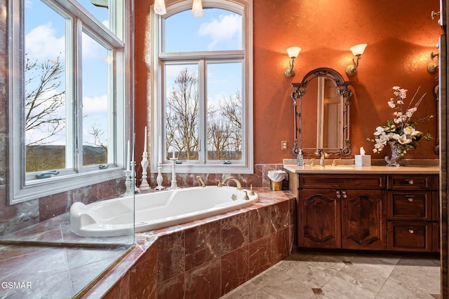 bathroom with a garden tub and vanity