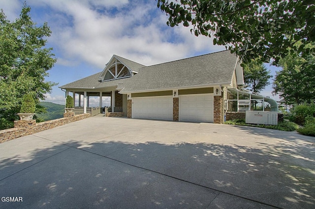 view of front facade featuring a garage, driveway, and a shingled roof