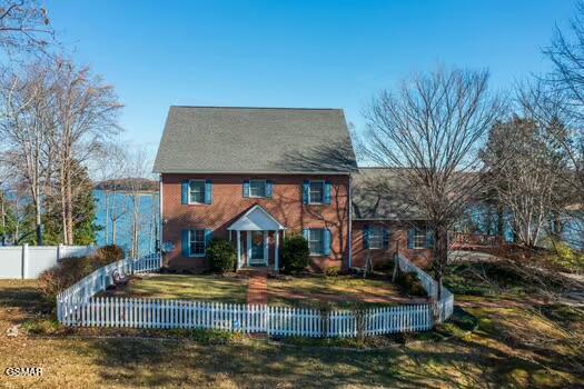 colonial-style house with a front lawn