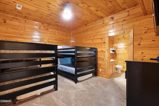 carpeted bedroom featuring connected bathroom, wooden walls, and wooden ceiling