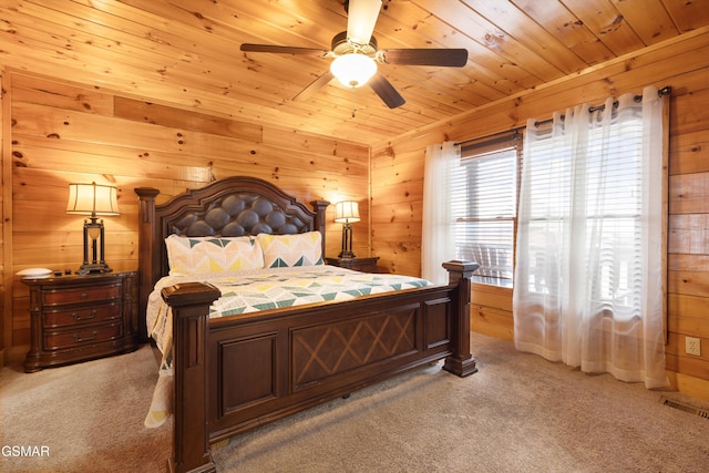 carpeted bedroom with ceiling fan, wooden walls, and wooden ceiling