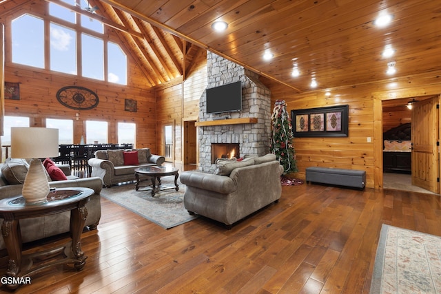 living room with wood ceiling, a stone fireplace, high vaulted ceiling, and hardwood / wood-style floors