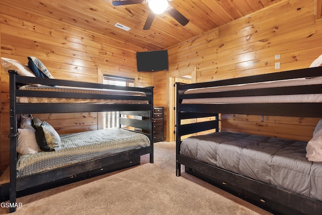 bedroom featuring ceiling fan, carpet, wooden walls, and wood ceiling