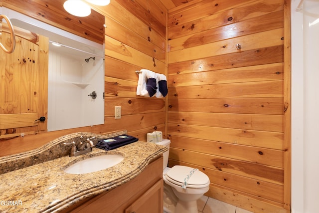 bathroom featuring walk in shower, tile patterned floors, toilet, vanity, and wooden walls