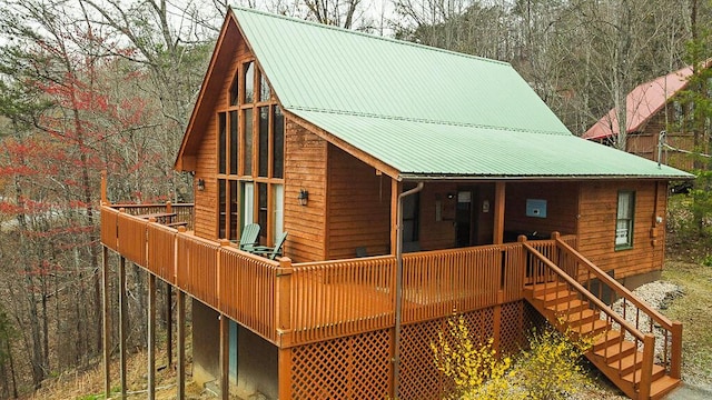 view of front of house featuring stairway, covered porch, and metal roof