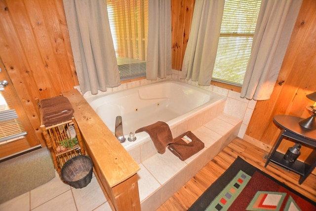 bathroom with wooden walls and a relaxing tiled tub