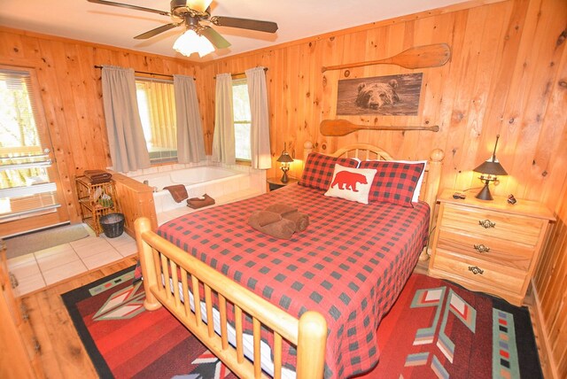 bedroom with ceiling fan, light wood-type flooring, and wooden walls