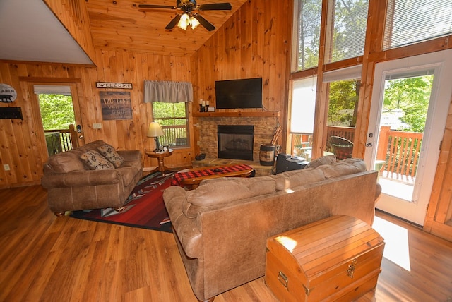 living room with ceiling fan, a fireplace, wood ceiling, and light wood-type flooring