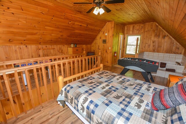 bedroom with wood ceiling, vaulted ceiling, ceiling fan, wooden walls, and light hardwood / wood-style flooring