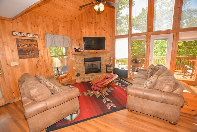 living room with a fireplace, hardwood / wood-style flooring, high vaulted ceiling, and ceiling fan