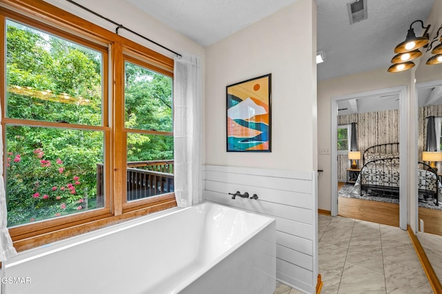 2489 Upper Middle Creek Rd, Sevierville, TN 37876 - full bath with marble finish floors, a freestanding tub, healthy amount of natural light, and a textured ceiling