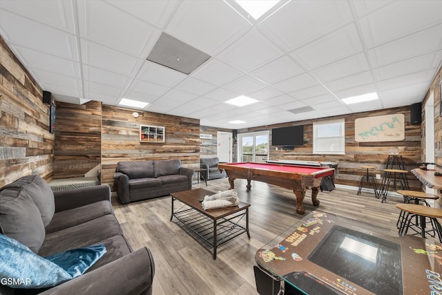 game room with pool table, wooden walls, wood finished floors, and a drop ceiling