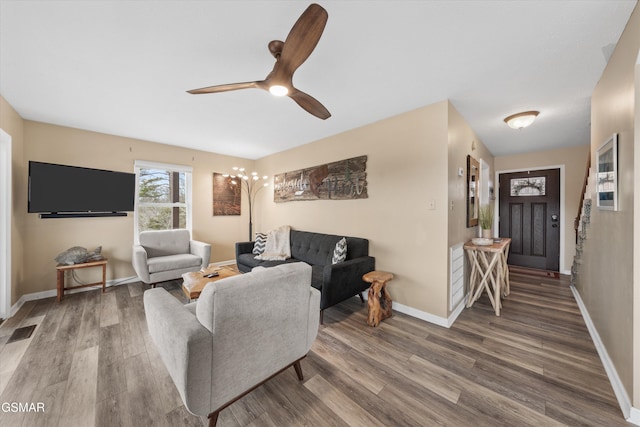 living room featuring ceiling fan, wood finished floors, visible vents, and baseboards