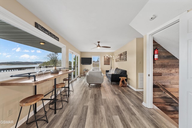 view of patio with outdoor wet bar, a ceiling fan, visible vents, and an outdoor living space