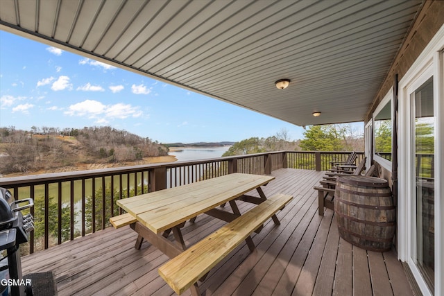 wooden deck featuring outdoor dining area and a water view