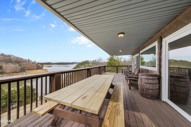 wooden terrace with outdoor dining space and a water view