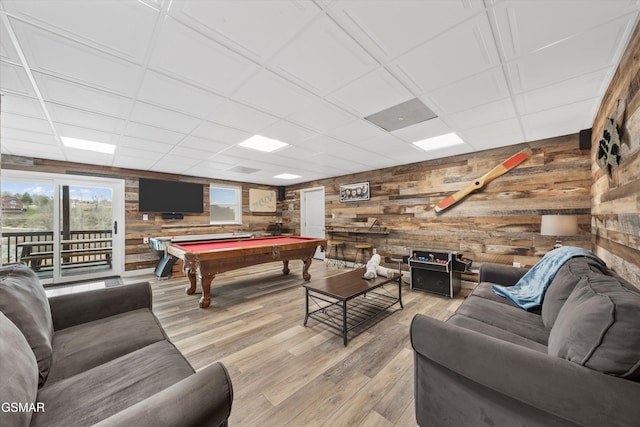 playroom with pool table, light wood-style flooring, a drop ceiling, and wood walls