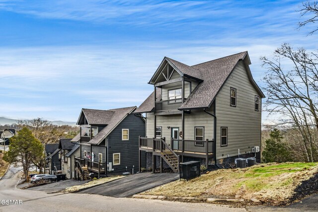 2125 Eagle Feather Dr, Sevierville, TN 37876 - view of side of home with a balcony, a shingled roof, stairway, a deck, and central AC