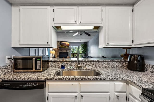 kitchen featuring ceiling fan, sink, light stone countertops, white cabinets, and appliances with stainless steel finishes